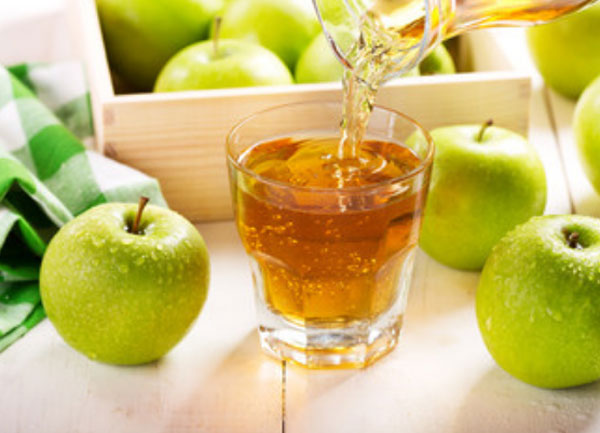 Стакан яблочного сока. Рядом зеленые яблоки