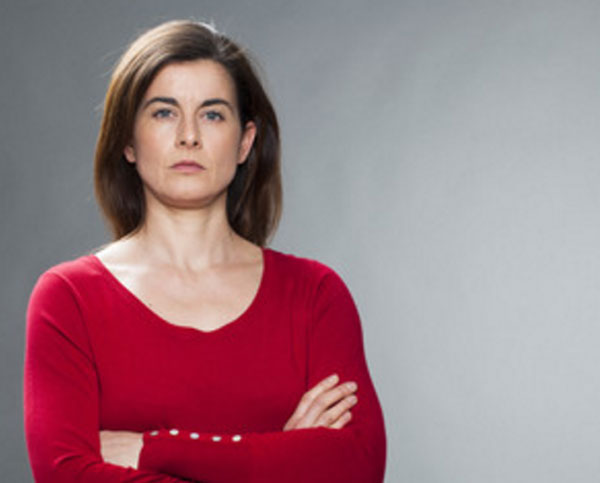 Серьезная женщина со сложенными руками