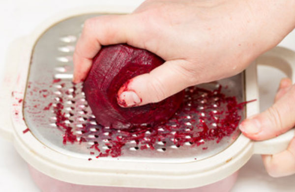 Женщина натирает свеклу на терке