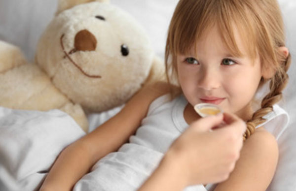 Девочке дают выпить сироп