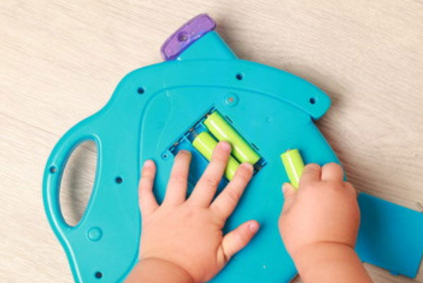 Ребенок достает батарейки из игрушки
