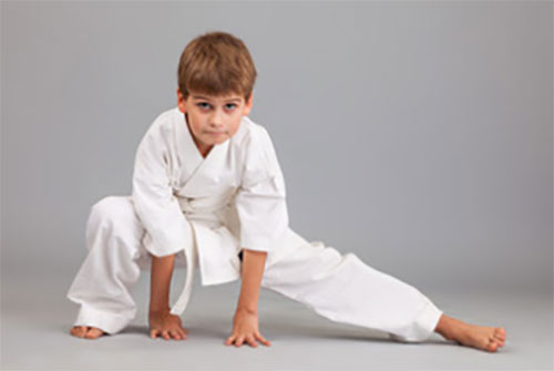 Мальчик, занимающийся боевыми искусствами, стоит в стойке