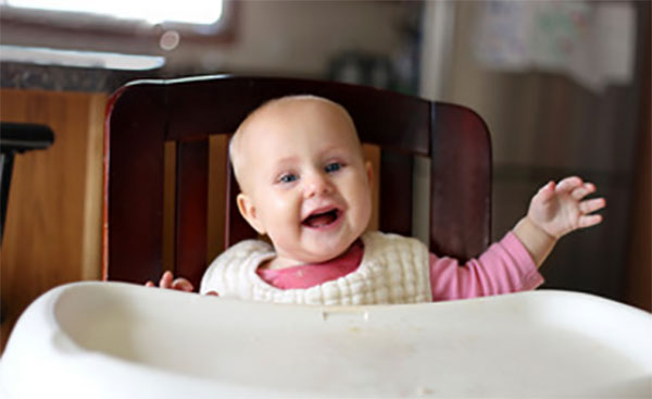 Восьмимесячный ребенок сидит за столиком