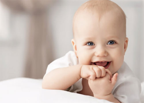 Счастливый ребенок лежит на животике