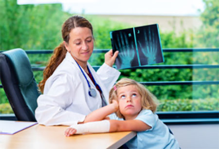 Врач с рентгеновскими снимками, рядом девочка с загипсованной рукой