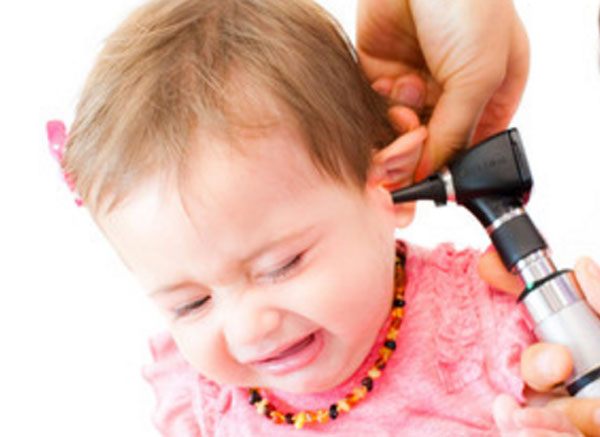 Доктор осматривает ухо маленькой девочки