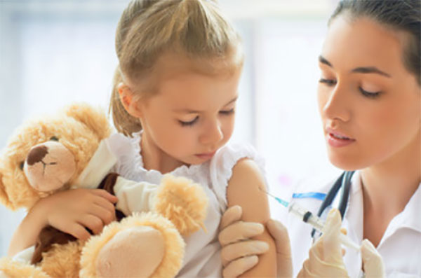 Доктор делает девочке прививку