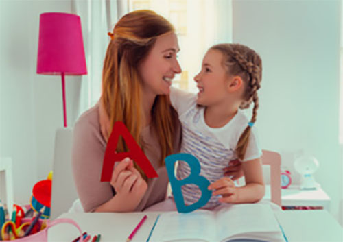 Мама с дочкой знакомятся с печатными буквами. Держат их в руках