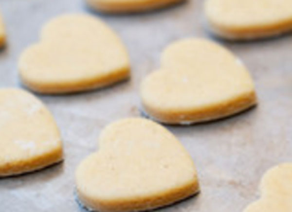 Сырое печенье в форме сердца на противне