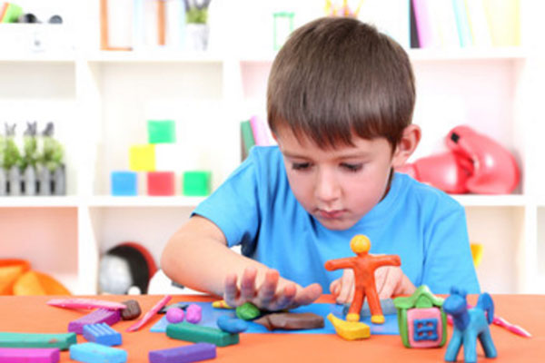 Мальчик лепит из пластилина