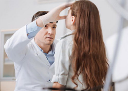 Врач осматривает нос девочки