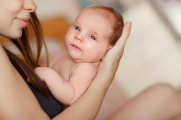 Мама сидит, держит на руках голенького ребенка