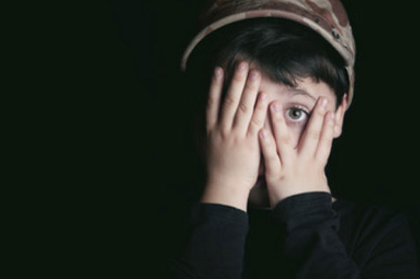 Мальчик боится, прикрывает лицо руками. Один глаз видно
