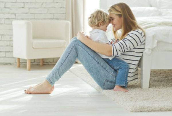 Ребенок сидит на маме. Она смотрит ему в глаза