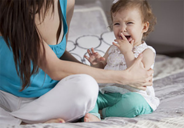 Мама смидит рядом с плачущим ребенком