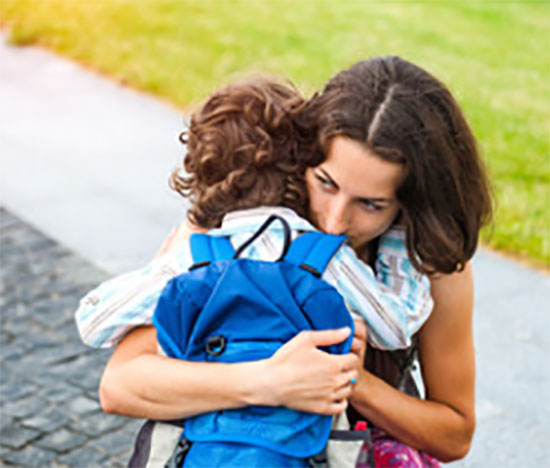 Мама обнимает своего маленького ученика