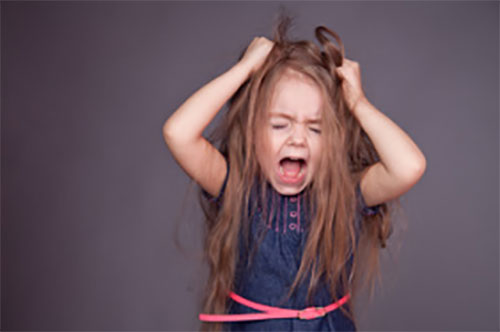 Девочка пытается вырвать себе волосы в приступе истерики