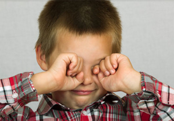 Мальчик трет глаза