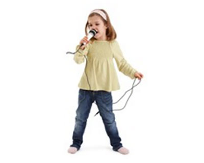 Девочка поет. В руках держит микрофон