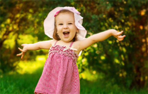 Радостная девочка в панамке и легком платьице