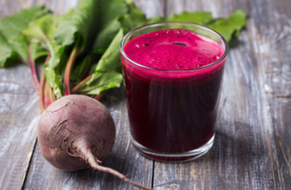 Стакан свекольного сока. Рядом лежит сырая свекла
