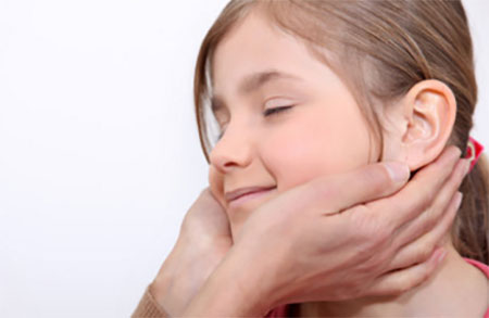 Девочке делают массаж. Руки специалиста опускаются к шее ребенка