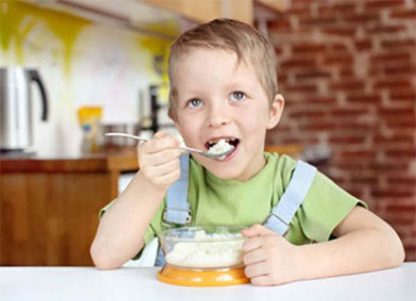 Мальчик ест кашу