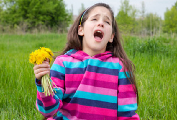 Девочка с открытым ртом. В руках держит букет одуванчиков