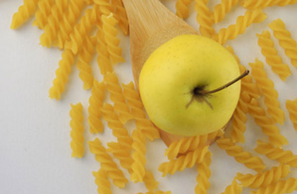 Сырые макароны и яблоко