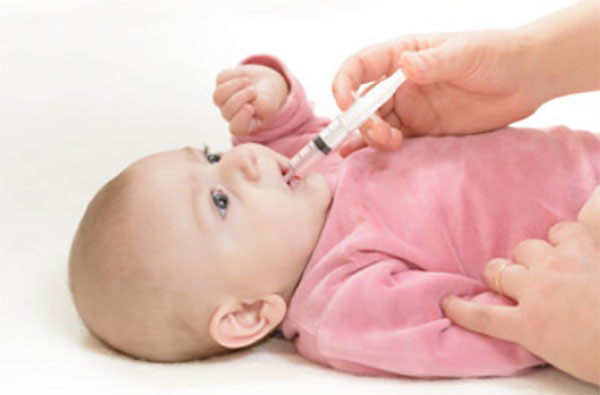 Ребенку дают лекарство со шприца