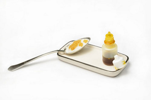 Настойка прополиса, рядом ложка сахара с несколькими каплями этой настойки