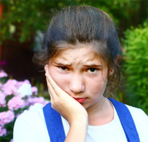 Девочка держится за щеку